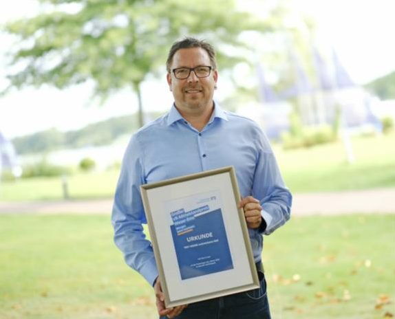 Preisträger hält die Urkunde zum VR-Mittelstandspreis Weser-Ems in die Kamera